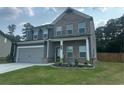 Attractive two-story home with brick and gray facade, a two-car garage, and a lush green lawn at 495 Sterling Creek Way, Loganville, GA 30052