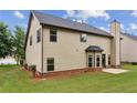 A home's backyard featuring green grass, vinyl siding, brick foundation, and a small patio at 8398 Members Dr, Jonesboro, GA 30236