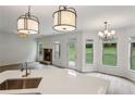 Bright open-concept living room with kitchen, fireplace, modern lighting, and backyard view at 8398 Members Dr, Jonesboro, GA 30236