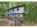 Back view of house with deck and wooded surroundings at 1352 Overlook Se Cv, Smyrna, GA 30080