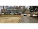 Traditional two-story home with a welcoming front porch, landscaped yard and an adjacent driveway with car at 3875 Wintergreen Ct, Marietta, GA 30062