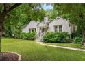 Charming white brick home with lush front yard, mature trees, and inviting walkway to entrance at 2119 Glenwood Se Ave, Atlanta, GA 30316