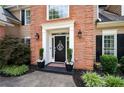 Close-up of home's front door shows well-kept landscaping, plants, and a brick facade at 2192 Nine Oaks Nw Dr, Kennesaw, GA 30152
