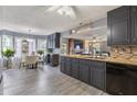 Well-lit open concept kitchen with granite countertops, dark cabinetry, and stainless steel appliances at 1433 Janice Sw Ct, Lilburn, GA 30047