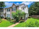 Traditional two-story townhome featuring a brick facade, a small porch, and verdant landscaping in a sunny, well-maintained community at 217 Odyssey Turn, Conyers, GA 30012
