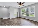 Inviting living room with hardwood floors, large windows, and a ceiling fan, creating a comfortable and airy ambiance at 217 Odyssey Turn, Conyers, GA 30012