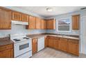 Traditional kitchen with wood cabinets, white appliances, and a double stainless steel sink at 4438 Parmalee Path, Conley, GA 30288