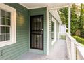 Covered front porch features a secure door with intricate metalwork and white railings at 1170 Westmont Sw Rd, Atlanta, GA 30311