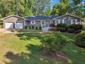 Two car garage, gray siding, and a well-manicured lawn enhance this lovely home's curb appeal at 2655 Nesbit Trl, Alpharetta, GA 30022
