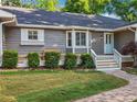 Inviting home with brick walkway, gray siding, white trim, and lush landscaping at 2655 Nesbit Trl, Alpharetta, GA 30022