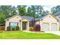 Well-maintained brick home with a green lawn, landscaping, and a two-car garage at 4220 Sawgrass Dr, Lithonia, GA 30038