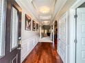 Elegant hallway with hardwood floors, crown molding, and decorative artwork at 4220 Sawgrass Dr, Lithonia, GA 30038