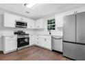 Bright kitchen featuring stainless appliances, white cabinets, quartz countertops, and hardwood flooring at 4800 Countryside E, Stone Mountain, GA 30083