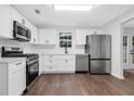 Bright kitchen featuring stainless appliances, white cabinets, quartz countertops, and hardwood flooring at 4800 Countryside E, Stone Mountain, GA 30083