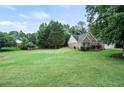 Spacious backyard showcasing lush green grass and mature trees, perfect for outdoor activities and relaxation at 7720 Paddocks Mill Dr, Cumming, GA 30041
