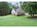 Brick home exterior with green lawn and shrubbery at 7720 Paddocks Mill Dr, Cumming, GA 30041