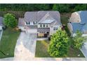 An aerial view of a home showing a well-manicured lawn, three-car garage, and mature trees at 139 Vinca Cir, Suwanee, GA 30024