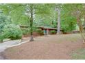 Well-manicured front lawn and tall trees complement this lovely brick home with a blue entry door at 3336 Forrest Hills Dr, Hapeville, GA 30354