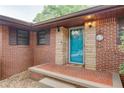 Inviting front porch with brick accents and a blue glass storm door at 3336 Forrest Hills Dr, Hapeville, GA 30354