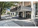 Daytime view of the building's entrance, awning and street view with signage visible at 620 Peachtree Ne St # 1001, Atlanta, GA 30308