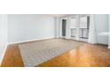 Spacious living room with wood floors, large windows with white drapes, and a neutral rug at 620 Peachtree Ne St # 1001, Atlanta, GA 30308