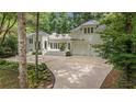 Beautiful white brick home featuring a circular driveway, an attached garage, and mature trees at 3089 Marne Nw Dr, Atlanta, GA 30305