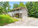 View of tan house with a white porch, basement access, and a two car garage at 400 Rustin Dr, Dallas, GA 30157