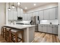 Modern kitchen featuring white cabinets, stainless steel appliances, and a spacious island with seating at 800 Old Plank Sq, Duluth, GA 30097