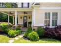 Inviting front porch with stone accents, ceiling fans, and manicured landscaping around the walkway at 2360 Whispering Nw Dr, Kennesaw, GA 30144