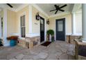 Close-up of front porch featuring a stone floor, ceiling fans, and elegant exterior lighting fixtures at 2360 Whispering Nw Dr, Kennesaw, GA 30144