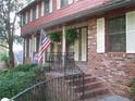 Welcoming front porch with brick stairs, black wrought iron railing and American flag at 4098 Nancy Creek Ne Way, Brookhaven, GA 30319