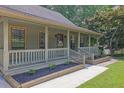 Inviting front porch with wood railing and trim, complemented by landscaped flower beds at 680 Spirit Falls Way, Johns Creek, GA 30022