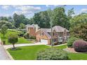Beautiful brick home with mature trees and a lush, green lawn at 742 Maggie Nw Ct, Kennesaw, GA 30144