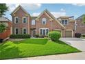 Charming two-story brick home with a lush green lawn and attached two-car garage at 5066 Healey Dr, Smyrna, GA 30082