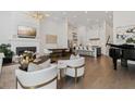 Bright, open living room featuring hardwood floors, modern furnishings, a fireplace, and a seamless transition to the kitchen at 6640 Avis Walk, Alpharetta, GA 30005