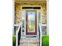 Elegant front door with decorative glass panels, stone accents, and a welcoming entrance at 1652 Park Hollow Ln, Lawrenceville, GA 30043