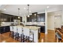 Spacious kitchen features dark cabinetry, granite countertops, stainless steel appliances and large center island at 8215 Harlond Way, Suwanee, GA 30024