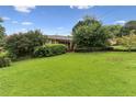Landscaped front yard with lush green lawn and mature trees enhancing curb appeal at 2711 Fairlane Dr, Atlanta, GA 30340