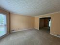 Spacious living room with neutral carpet, textured ceiling, and a large window at 25 Darcee Ct, Lawrenceville, GA 30046