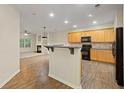 Open kitchen featuring wood cabinets, black appliances, and views of the living room at 3300 Suttles Sw Dr, Atlanta, GA 30331