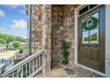 Inviting entryway with a stone porch, decorative wreath on the front door, and a potted plant at 406 Mareeba Park # 61, Canton, GA 30114