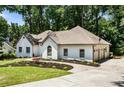 White brick house with attached three car garage, mature trees and manicured lawn at 251 Waller Nw Cir, Marietta, GA 30064