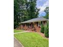 Charming brick home featuring a well-maintained lawn, flower boxes, and black shutters at 406 S Hillcrest Sw Dr, Marietta, GA 30064