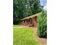 Beautiful brick home with a bright yellow door, flower boxes, and a lush green lawn at 406 S Hillcrest Sw Dr, Marietta, GA 30064