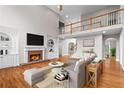Bright living room with hardwood floors, fireplace, built-in shelving, and views of the second story loft at 1000 Gunter Ct, Alpharetta, GA 30022