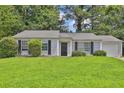 Single-story home with well-kept lawn, trimmed shrubs, and a one-car garage at 1234 Wellhouse Walk, Stone Mountain, GA 30088