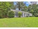 Traditional single-story home with a lush green lawn and mature landscaping at 1234 Wellhouse Walk, Stone Mountain, GA 30088