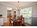 Traditional dining room boasts wood floors, a chandelier, large windows, and classic molding at 2540 Ridgehurst Dr, Buford, GA 30518