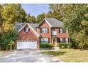 Two-story brick home featuring well-maintained landscaping, a two-car garage, and a traditional facade at 2540 Ridgehurst Dr, Buford, GA 30518
