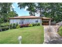 Traditional home with a lush lawn, mature trees, and a carport at 2646 Rockcliff Road Se, Atlanta, GA 30316